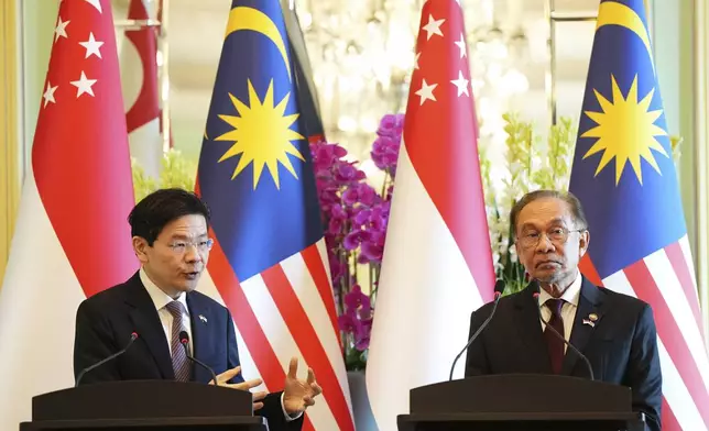 Singapore Prime Minister Lawrence Wong, left, speaks during a press conference with Malaysian Prime Minister Anwar Ibrahim at the prime minister's office in Putrajaya, Malaysia, Tuesday, Jan. 7, 2025. (AP Photo/Vincent Thian, Pool)