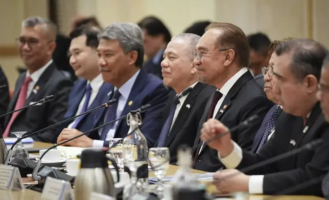 Malaysian Prime Minister Anwar Ibrahim, third from right, with his cabinet ministers meets with Singapore Prime Minister Lawrence Wong and his delegation members, unseen, at the prime minister's office in Putrajaya, Malaysia, Tuesday, Jan. 7, 2025. (AP Photo/Vincent Thian, Pool)