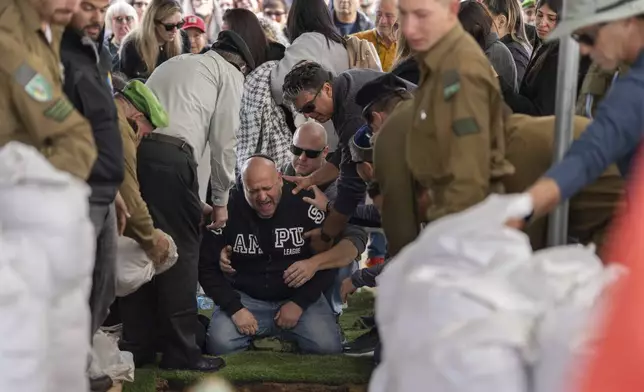 Nir, the father of Israeli soldier Sergeant Yahav Maayan who was killed in combat in the Gaza Strip, reacts next to his son's grave during his funeral at a military cemetery in Modiin, Israel, Sunday, Jan. 12, 2025. (AP Photo/Ohad Zwigenberg)