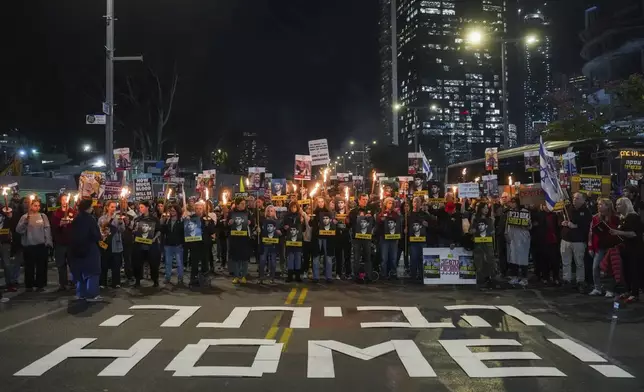 Demonstrators hold torches during a protest calling for the immediate release of the hostages held in the Gaza Strip by the Hamas militant group in Tel Aviv, Israel, on Monday, Jan. 13, 2025. (AP Photo/Ohad Zwigenberg)
