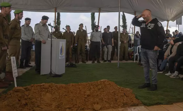 Nir, father of Israeli soldier Sergeant Yahav Maayan who was killed in combat in the Gaza Strip, reacts next to his son's grave during his funeral at a military cemetery in Modiin, Israel, Sunday, Jan. 12, 2025. (AP Photo/Ohad Zwigenberg)