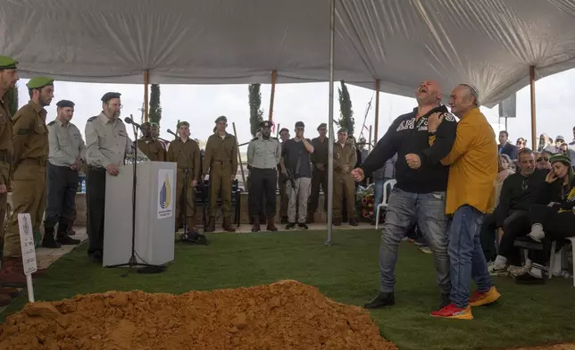 Nir, father of Israeli soldier Sergeant Yahav Maayan who was killed in combat in the Gaza Strip, reacts next to his son's grave during his funeral at a military cemetery in Modiin, Israel, Sunday, Jan. 12, 2025. (AP Photo/Ohad Zwigenberg)