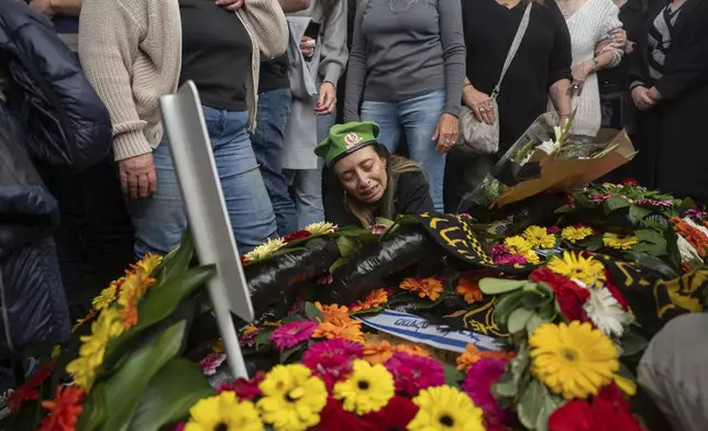 Gali, whose son, Sgt. Yahav Maayan, was killed in combat in the Gaza Strip, reacts next to his grave during his funeral at a military cemetery in Modiin, Israel, Sunday, Jan. 12, 2025. (AP Photo/Ohad Zwigenberg)