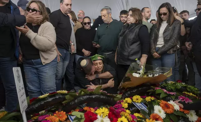 Gali the mother of the Israeli soldier Sergeant Yahav Maayan who was killed in combat in the Gaza Strip, reacts next to his son's grave during his funeral at a military cemetery in Modiin, Israel, Sunday, Jan. 12, 2025. (AP Photo/Ohad Zwigenberg)