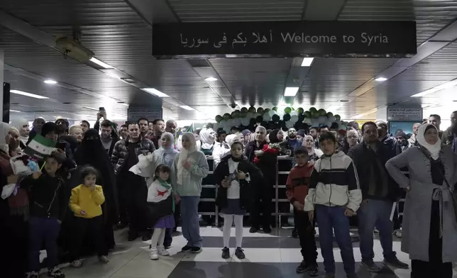 People wait to receive their relatives at the arrival terminal, after a first international commercial flight since the fall of former Syrian President Bashar Assad landed at Damascus international airport, in Damascus, Syria, Tuesday, Jan. 7, 2025. (AP Photo/Omar Sanadiki)