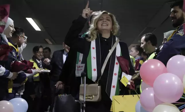 A Syrian woman who arrived at a first international commercial flight since the fall of former Syrian President Bashar Assad shouts anti-Assad slogans at the arrival terminal of Damascus international airport, in Damascus, Syria, Tuesday, Jan. 7, 2025. (AP Photo/Omar Sanadiki)