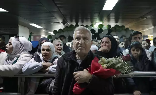 People wait to receive their relatives at the arrival terminal, after a first international commercial flight since the fall of former Syrian President Bashar Assad landed at Damascus international airport, in Damascus, Syria, Tuesday, Jan. 7, 2025. (AP Photo/Omar Sanadiki)