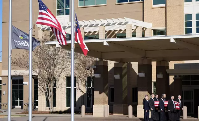 Former and current U.S. Secret Service agents assigned to the Carter detail, move the flag-draped casket of former President Jimmy Carter, at Phoebe Sumter Medical Center in Americus, Ga., Saturday, Jan. 4, 2025. Carter died Dec. 29 at the age of 100. (AP Photo/Alex Brandon, Pool)