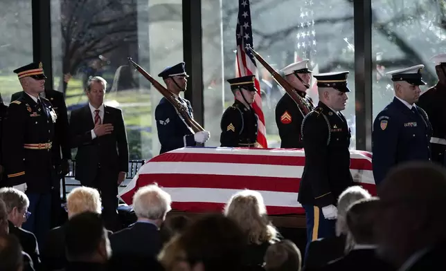 A military body bear teams places the flag-draped casket of former President Jimmy Carter onto the catafalque at the Jimmy Carter Presidential Library and Museum in Atlanta, Saturday, Jan. 4, 2025. Carter died Dec. 29 at the age of 100. (AP Photo/Alex Brandon, Pool)