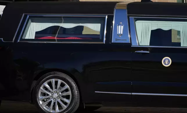 The flag-draped casket of former President Jimmy Carter is placed into the hearse before it departs Phoebe Sumter Medical Center in Americus, Ga., Saturday, Jan. 4, 2025. Carter died Dec. 29 at the age of 100. (AP Photo/Alex Brandon, Pool)