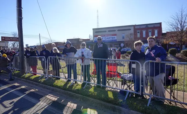 People line the street in Plains, Ga., before the hearse carrying the casket of former President Jimmy Carter passes through the town Saturday, Jan. 4, 2025. Carter died Dec. 29 at the age of 100. (AP Photo/Alex Brandon, Pool)