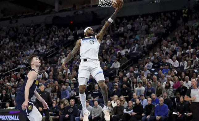 Minnesota Timberwolves guard Nickeil Alexander-Walker (9) shoots past Denver Nuggets guard Christian Braun (0) during the first half of an NBA basketball game, Saturday, Jan. 25, 2025, in Minneapolis. (AP Photo/Ellen Schmidt)