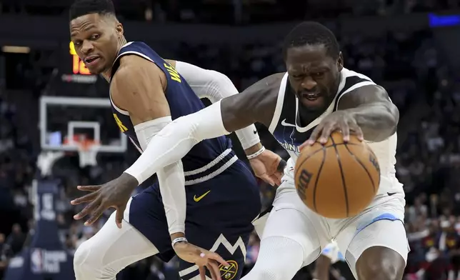 Minnesota Timberwolves forward Julius Randle, right, vies for a loose ball while Denver Nuggets guard Russell Westbrook defends during the first half of an NBA basketball game, Saturday, Jan. 25, 2025, in Minneapolis. (AP Photo/Ellen Schmidt)