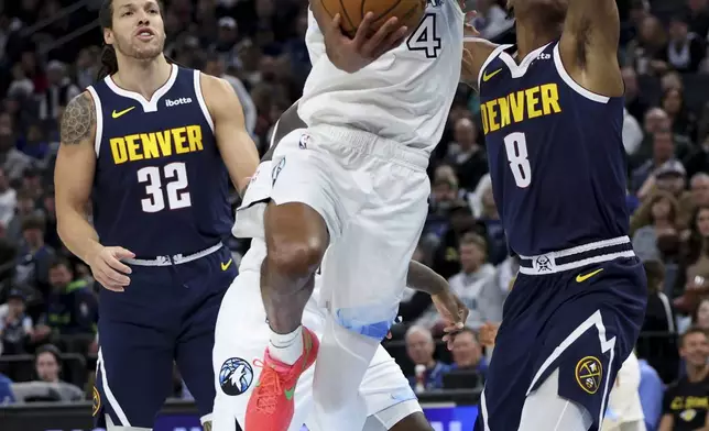 Minnesota Timberwolves guard Rob Dillingham (4) shoots over Denver Nuggets forward Peyton Watson (8) while Nuggets forward Aaron Gordon (32) looks on during the first half of an NBA basketball game, Saturday, Jan. 25, 2025, in Minneapolis. (AP Photo/Ellen Schmidt)