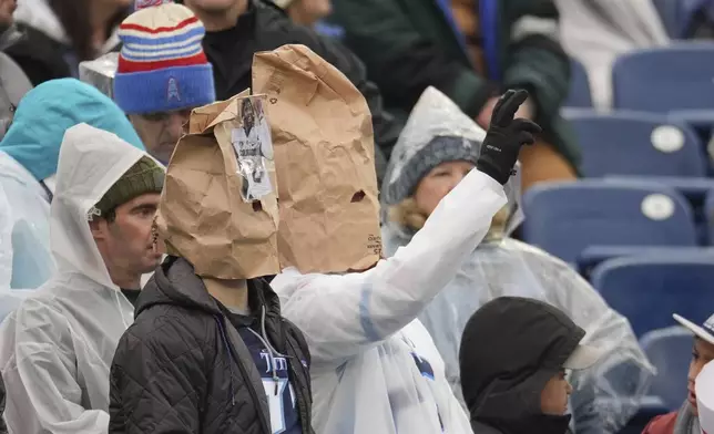 Tennessee Titans fans wear bags over their heads as they watch during the second half of an NFL football game against the Houston Texans Sunday, Jan. 5, 2025, in Nashville, Tenn. (AP Photo/George Walker IV)