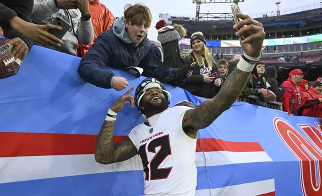 Houston Texans wide receiver Nico Collins (12) celebrates with a fan after an NFL football game against the Tennessee Titans Sunday, Jan. 5, 2025, in Nashville, Tenn. The Texans won 23-14. (AP Photo/John Amis)