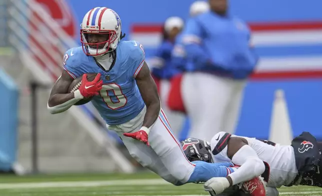 Tennessee Titans wide receiver Calvin Ridley (0) is tackled by Houston Texans' Eric Murray after catching a pass during the first half of an NFL football game Sunday, Jan. 5, 2025, in Nashville, Tenn. (AP Photo/George Walker IV)