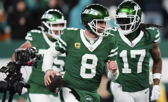 New York Jets quarterback Aaron Rodgers (8) reacts following his 500th career regular-season touchdown pass during the first half of an NFL football game against the Miami Dolphins, Sunday, Jan. 5, 2025, in East Rutherford, N.J. (AP Photo/Seth Wenig)