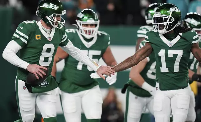 New York Jets quarterback Aaron Rodgers (8) celebrates with wide receiver Davante Adams (17) after throwing his 500th career regular-season touchdown pass during the first half of an NFL football game against the Miami Dolphins, Sunday, Jan. 5, 2025, in East Rutherford, N.J. (AP Photo/Seth Wenig)