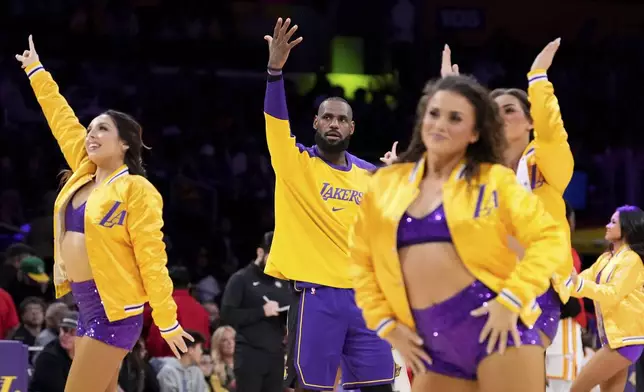 Los Angeles Lakers forward LeBron James, center, argues with a referee as members of the Laker Girls dance around him during timeout in the second half of an NBA basketball game against the Atlanta Hawks, Friday, Jan. 3, 2025, in Los Angeles. (AP Photo/Mark J. Terrill)