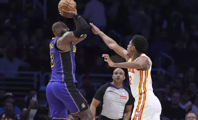 Los Angeles Lakers forward LeBron James, left, shoots as Atlanta Hawks forward De'Andre Hunter defends during the second half of an NBA basketball game, Friday, Jan. 3, 2025, in Los Angeles. (AP Photo/Mark J. Terrill)