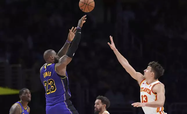 Los Angeles Lakers forward LeBron James (23) shoots as Atlanta Hawks guard Bogdan Bogdanovic (13) defends during the second half of an NBA basketball game, Friday, Jan. 3, 2025, in Los Angeles. (AP Photo/Mark J. Terrill)