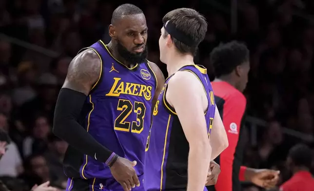 Los Angeles Lakers forward LeBron James, left, celebrates with guard Austin Reaves after making his 30th point of the game during the second half of an NBA basketball game against the Atlanta Hawks, Friday, Jan. 3, 2025, in Los Angeles. With that shot, James surpassed Michael Jordon for most 30-point regular season games in NBA history. (AP Photo/Mark J. Terrill)