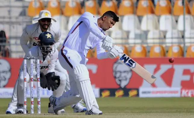 West Indies Gudakesh Motie, front, plays a shot as Pakistan's Mohammad Rizwan, center, and Salma Ali Agha watch during the day-one of the second cricket test match between Pakistan and West Indies, in Multan, Pakistan, Saturday, Jan. 25, 2025. (AP Photo/Asim Tanveer)