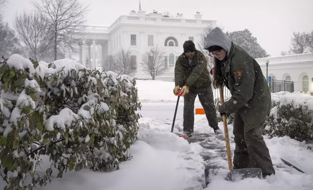 National Park Service workers shovel a pathway during a winter storm at the White House, Monday, Jan. 6, 2025, in Washington. (AP Photo/Mark Schiefelbein)