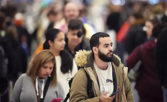 Hundreds of passengers wait to clear a security checkpoint as Kansas City International Airport worked to return to normal flight operations following flight delays and cancellations during a winter storm, Monday, Jan. 6, 2025, in Kansas City, Mo. (AP Photo/Charlie Riedel)