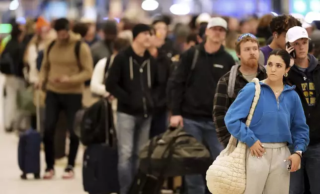 Hundreds of passengers wait to clear a security checkpoint as Kansas City International Airport worked to return to normal flight operations following flight delays and cancellations during a winter storm, Monday, Jan. 6, 2025 in Kansas City, Mo. (AP Photo/Charlie Riedel)