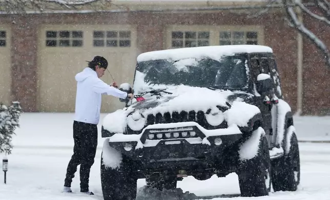 A motorist clears now off a four-wheel-drive vehicle before taking to the roads as a winter storm sweeps over the intermountain West and across the country Tuesday, Jan. 7, 2025, in Denver. (AP Photo/David Zalubowski)