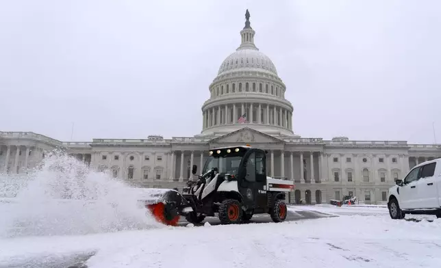 A snowplow clears the area as snow blankets Capitol Hill ahead of a joint session of Congress to certify the votes from the Electoral College in the presidential election in Washington, Monday, Jan. 6, 2025. (AP Photo/Jose Luis Magana)