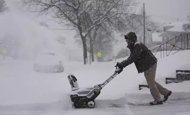 Carl Rich uses a snowblower to clear his driveway during a winter storm, Monday, Jan. 6, 2025, in Cincinnati. (AP Photo/Joshua A. Bickel)