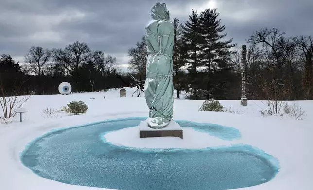 "Aurelia Roma", a 1994 Italian marble sculpture by Manuel Neri, is wrapped for the season as she stands in the pool of the Estate House terrace surrounded by snow at Laumeier Sculpture Park in Sunset Hills, Mo. on Monday, Jan. 6, 2025. (Robert Cohen/St. Louis Post-Dispatch via AP)