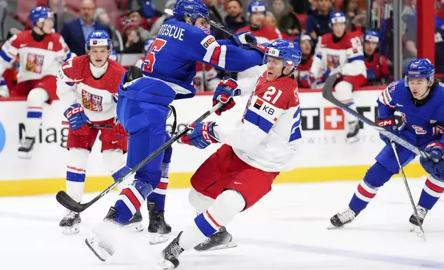 United States defenseman Drew Fortescue (5) checks Czechia forward Jakub Stancl (21) during second-period World Junior hockey championship semifinal game action in Ottawa, Ontario, Saturday, Jan. 4, 2025. (Sean Kilpatrick/The Canadian Press via AP)