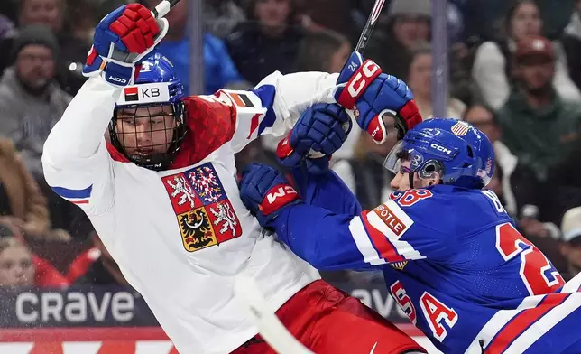 United States defenseman Zeev Buium (28) shoves Czechia forward Adam Novotny, left, during second-period World Junior hockey championship semifinal game action in Ottawa, Ontario, Saturday, Jan. 4, 2025. (Sean Kilpatrick/The Canadian Press via AP)