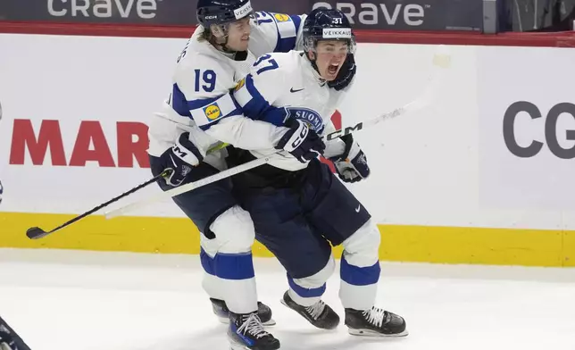 Finland forward Konsta Helenius (19) hugs Benjamin Rautiainen (37) after Rautiainen scored the game winning goal in overtime against Sweden in a semifinal game at the world junior hockey championship, Saturday, Jan. 4, 2025 in Ottawa, Ontario. (Adrian Wyld/The Canadian Press via AP)