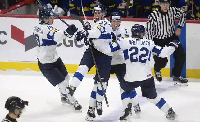Finland's Benjamin Rautiainen (37) celebrates with teammates Rasmus Kumpulainen (18), Kasper Halttunen (22) and Konsta Helenius after scoring the game winning goal in overtime against Sweden in a semifinal game at the world junior hockey championship, Saturday, Jan. 4, 2025 in Ottawa, Ontario. (Adrian Wyld/The Canadian Press via AP)