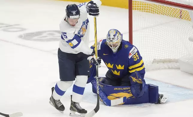 Finland forward Tuomas Uronen (15) tries to tip a shot past Sweden goaltender Melker Thelin (35) during the second period of a semifinal game at the world junior hockey championship, Saturday, Jan. 4, 2025 in Ottawa, Ontario. (Adrian Wyld/The Canadian Press via AP)