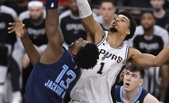 San Antonio Spurs' Victor Wembanyama (1) blocks a shot-attempt by Memphis Grizzlies' Jaren Jackson Jr. (13) during the first half of an NBA basketball game, Friday, Jan. 17, 2025, in San Antonio. (AP Photo/Darren Abate)