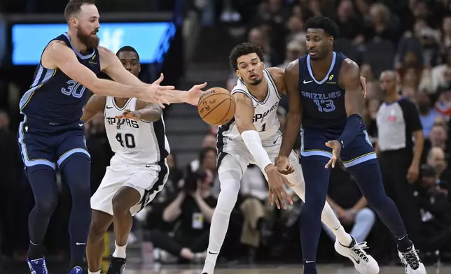Memphis Grizzlies' Jay Huff (30) and Jaren Jackson Jr. (13) tangle with San Antonio Spurs' Victor Wembanyama (1) and Harrison Barnes (40) during the first half of an NBA basketball game, Friday, Jan. 17, 2025, in San Antonio. (AP Photo/Darren Abate)