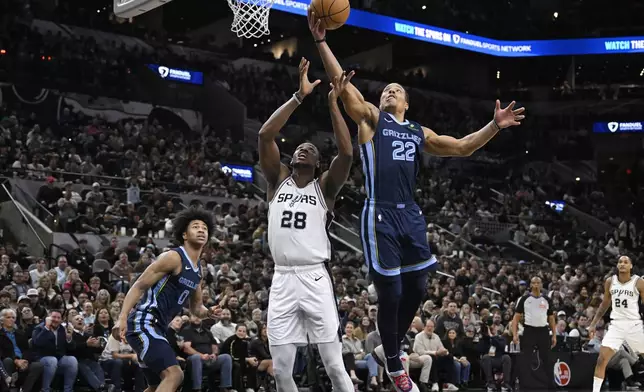 Memphis Grizzlies' Desmond Bane (22) grabs the rebound ahead of San Antonio Spurs' Charles Bassey during the first half of an NBA basketball game, Friday, Jan. 17, 2025, in San Antonio. (AP Photo/Darren Abate)