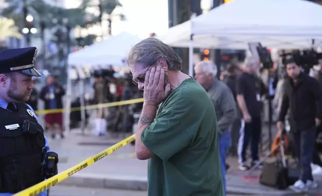 Edward Bruski, center, is emotional at the scene where a vehicle drove into a crowd on New Orleans' Canal and Bourbon Street, Wednesday Jan. 1, 2025. (AP Photo/Gerald Herbert)