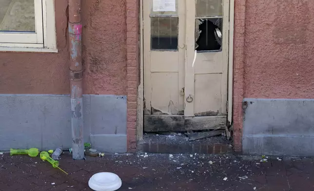 A damaged door stands on Bourbon Street after members of the FBI and bomb squad detonated a suspicious package during the investigation after a pickup truck rammed into a crowd of revelers early on New Year's Day, Wednesday, Jan. 1, 2025, in New Orleans. (AP Photo/Matthew Hinton)