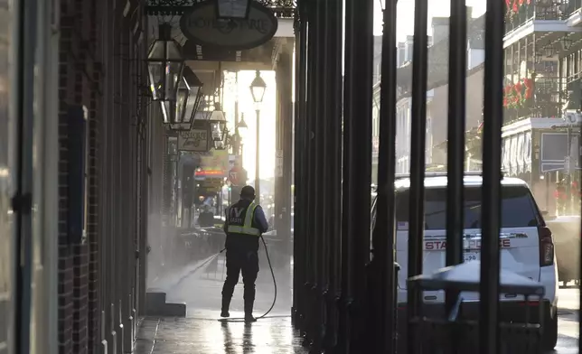 A man uses a power washer on Toulouse street a day after a vehicle was driven into a crowd on New Orleans' Canal and Bourbon streets, Thursday, Jan. 2, 2025. (AP Photo/George Walker IV)