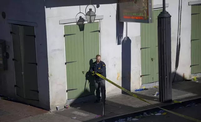 Members of the FBI apply crime scene tape on Bourbon Street during the investigation of a truck fatally crashing into pedestrians on Bourbon Street in the French Quarter in New Orleans, Wednesday, Jan. 1, 2025. (AP Photo/Matthew Hinton)