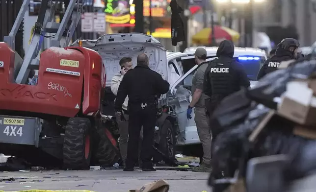 Emergency services attend the scene on Bourbon Street after a vehicle drove into a crowd on New Orleans' Canal and Bourbon Street, Wednesday Jan. 1, 2025. (AP Photo/Gerald Herbert)