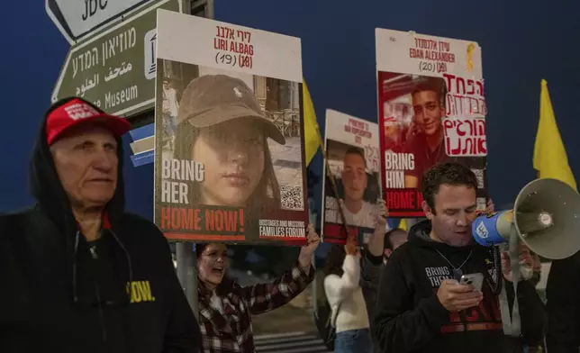 Israeli demonstrators outside the prime minister's office in Jerusalem hold photos of Liri Albag and other hostages during a protest calling for their release from being held in the Gaza Strip by the Hamas militant group, Sunday, Jan. 5, 2025. (AP Photo/Ohad Zwigenberg)