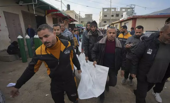 Mourners carry the bodies of three members of Imad Al-deen family who were killed in the Israeli bombardment in Bureij, central Gaza Strip, at Al-Aqsa Martyrs Hospital in Deir al-Balah, Monday, Jan. 6, 2025. (AP Photo/Abdel Kareem Hana)